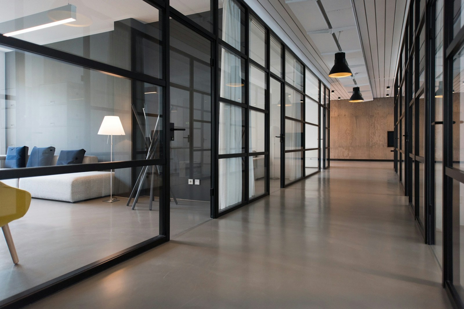Temporary stock: contemporary office corridor with glass partitions and wood finishes
