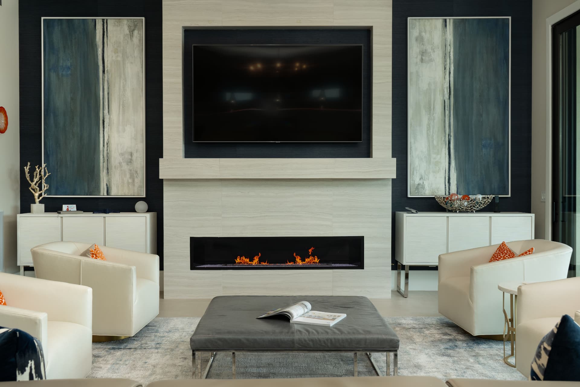 Symmetrical living room with a fireplace, stone feature wall, and pale lounge chairs
