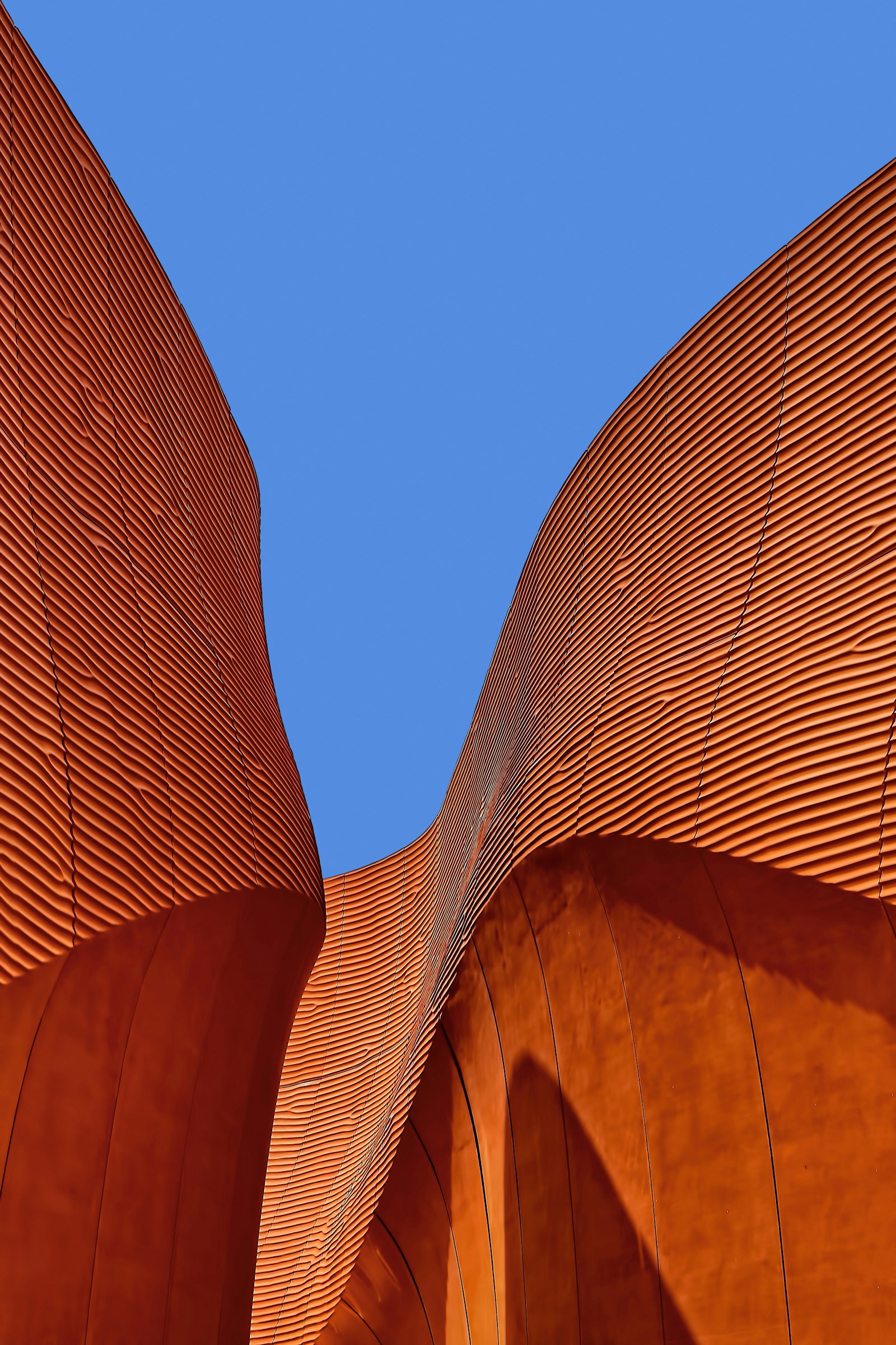 Temporary stock: sculptural terracotta-colored cultural building with curved walls